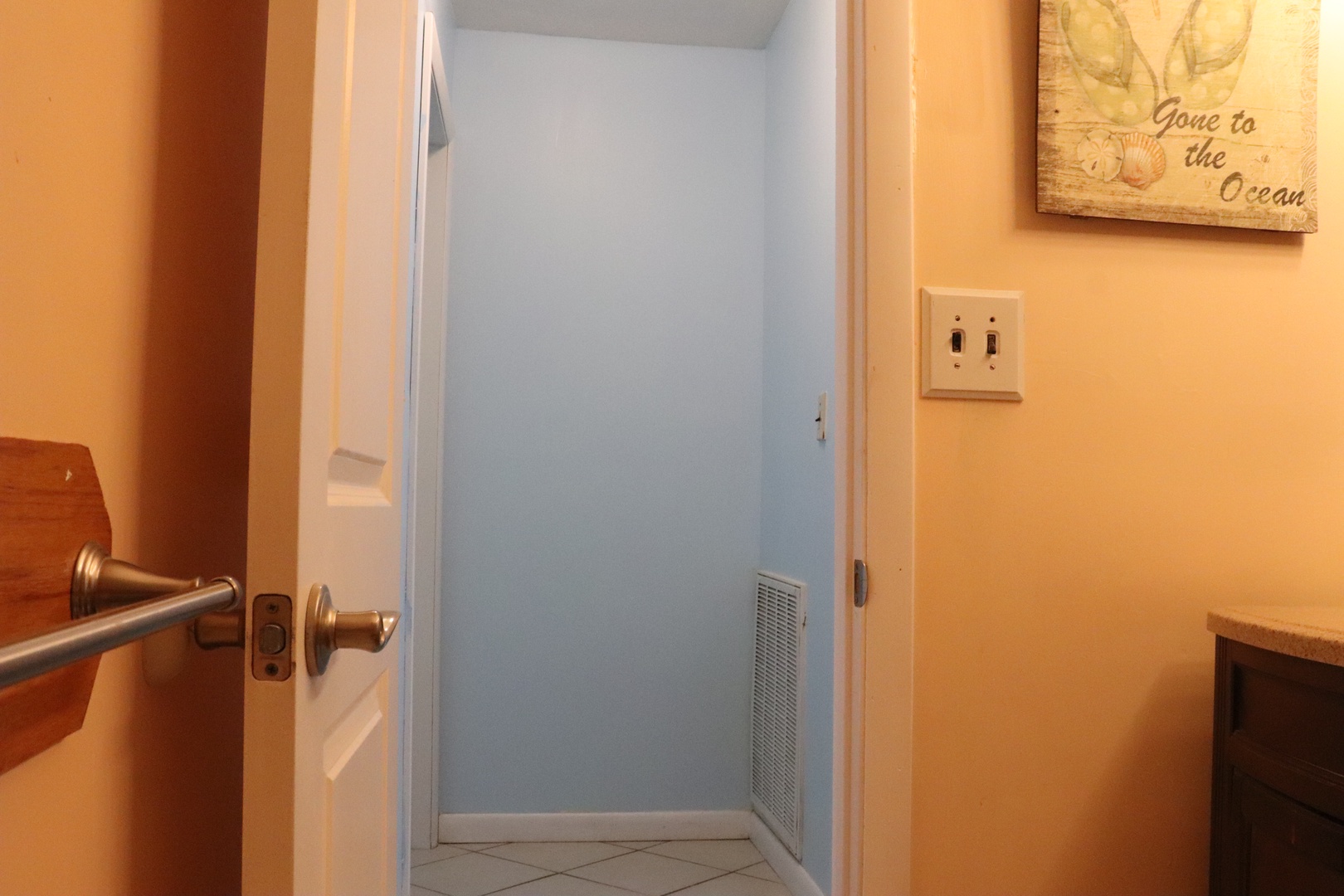 Step inside this cheerful, beach-themed bathroom. Warm peach walls and a soft blue accent welcome you—perfect for freshening up after a day of fun and sun.