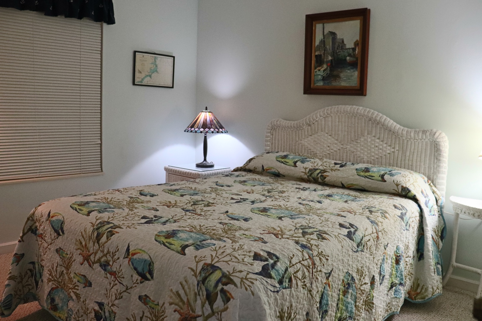 Sleep peacefully in your cozy bedroom with soft natural light filtering through blinds and charming local artwork.