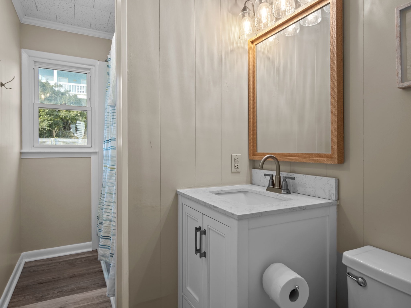 Your private bathroom features elegant marble countertops, warm wood-framed mirror, and stylish lighting for your comfort.