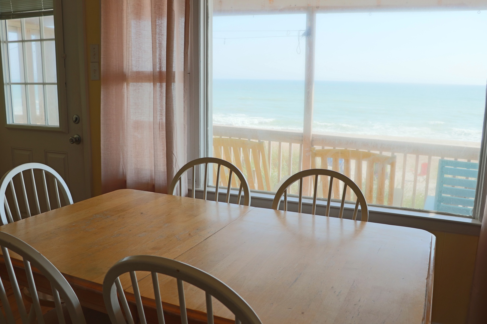 Gather around your dining table with stunning ocean views stretching beyond the deck railing.