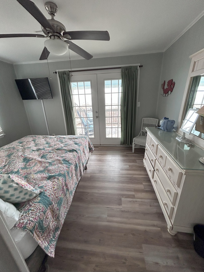 Relax in your peaceful bedroom with ocean-inspired decor, ceiling fan comfort, and French doors opening to your private balcony.