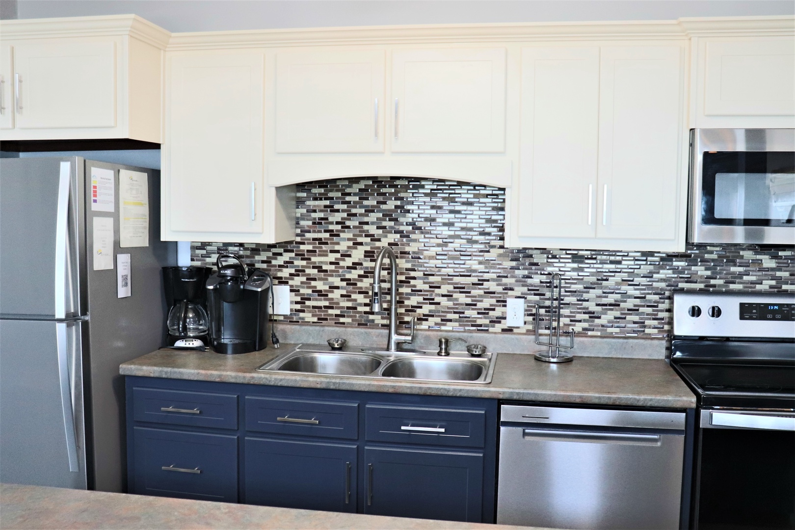 Your fully equipped kitchen features modern appliances and stylish tile backsplash, perfect for preparing meals during your stay.