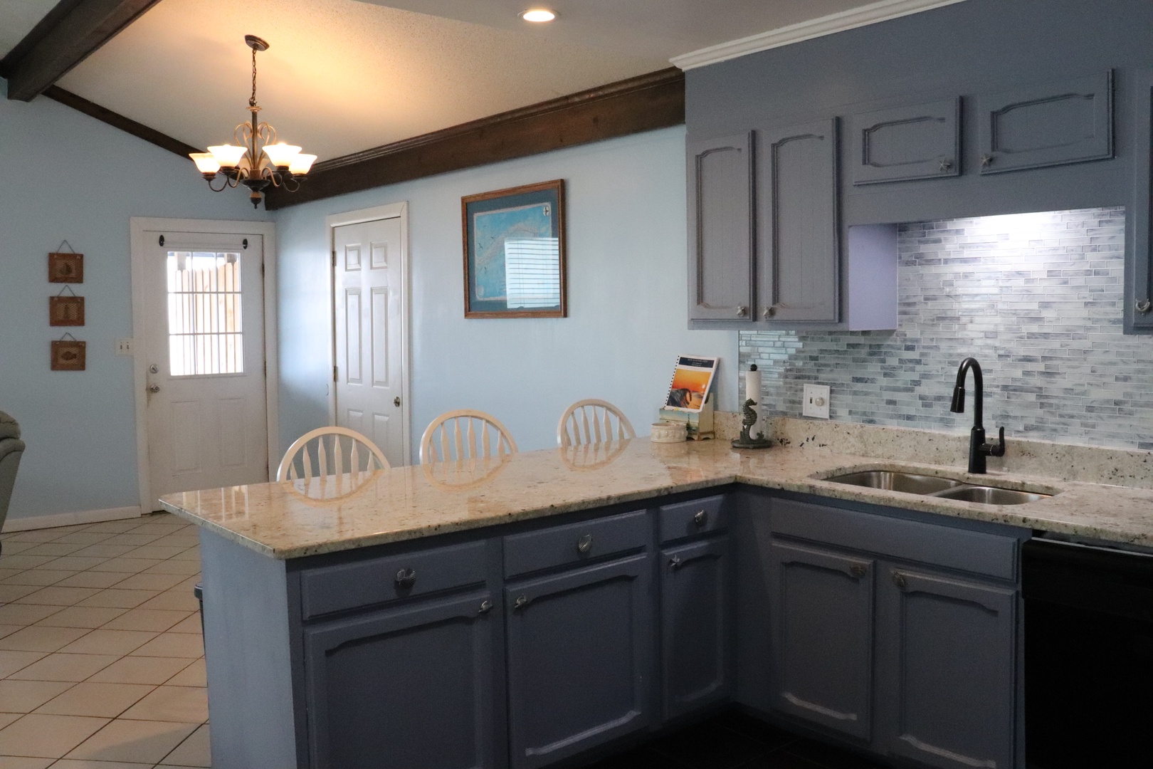 Your spacious kitchen invites you to gather around the island, fully equipped with modern amenities and coastal charm to make meal prep effortless and enjoyable.