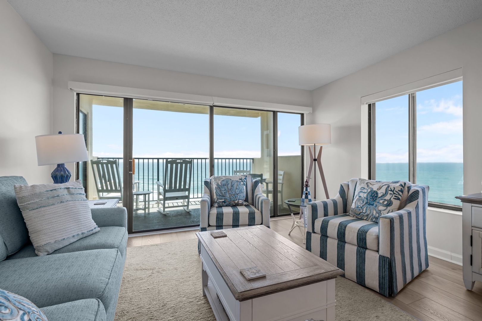 Sink into coastal comfort in your bright oceanfront living room, where panoramic sea views and soothing blue décor create the perfect beach retreat.