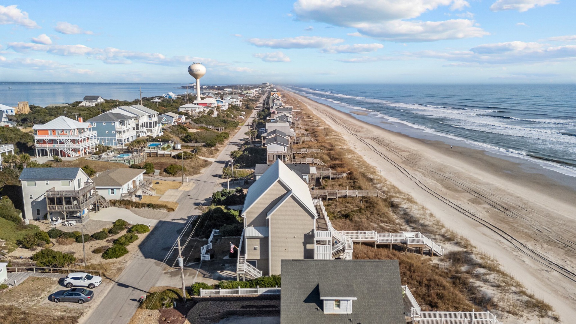 Expansive oceanfront coastline with beach houses dotting the sandy shore and pristine Atlantic waters stretching to the horizon.