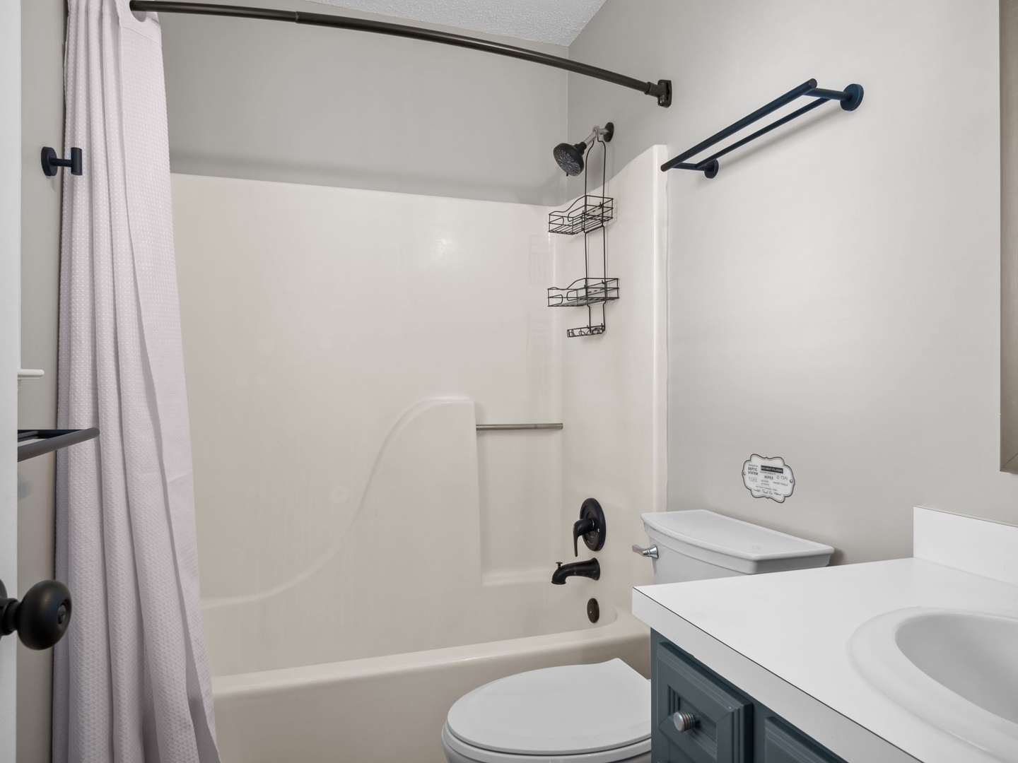 Your clean, modern bathroom features a tub-shower combo with handy storage caddies and fresh towels for your relaxing soak.