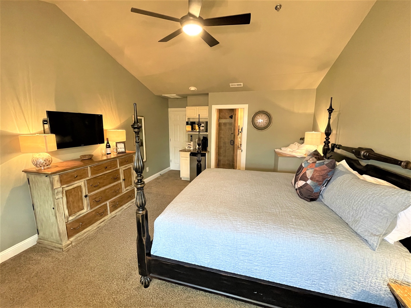 Unwind in your elegant master suite with crisp linens, a ceiling fan for comfort, and convenient entertainment setup.