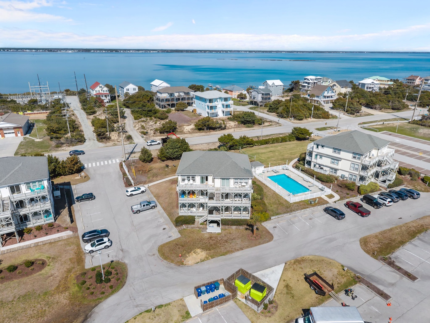 Aerial view of coastal vacation rental community featuring beachfront properties with swimming pool and easy beach access.
