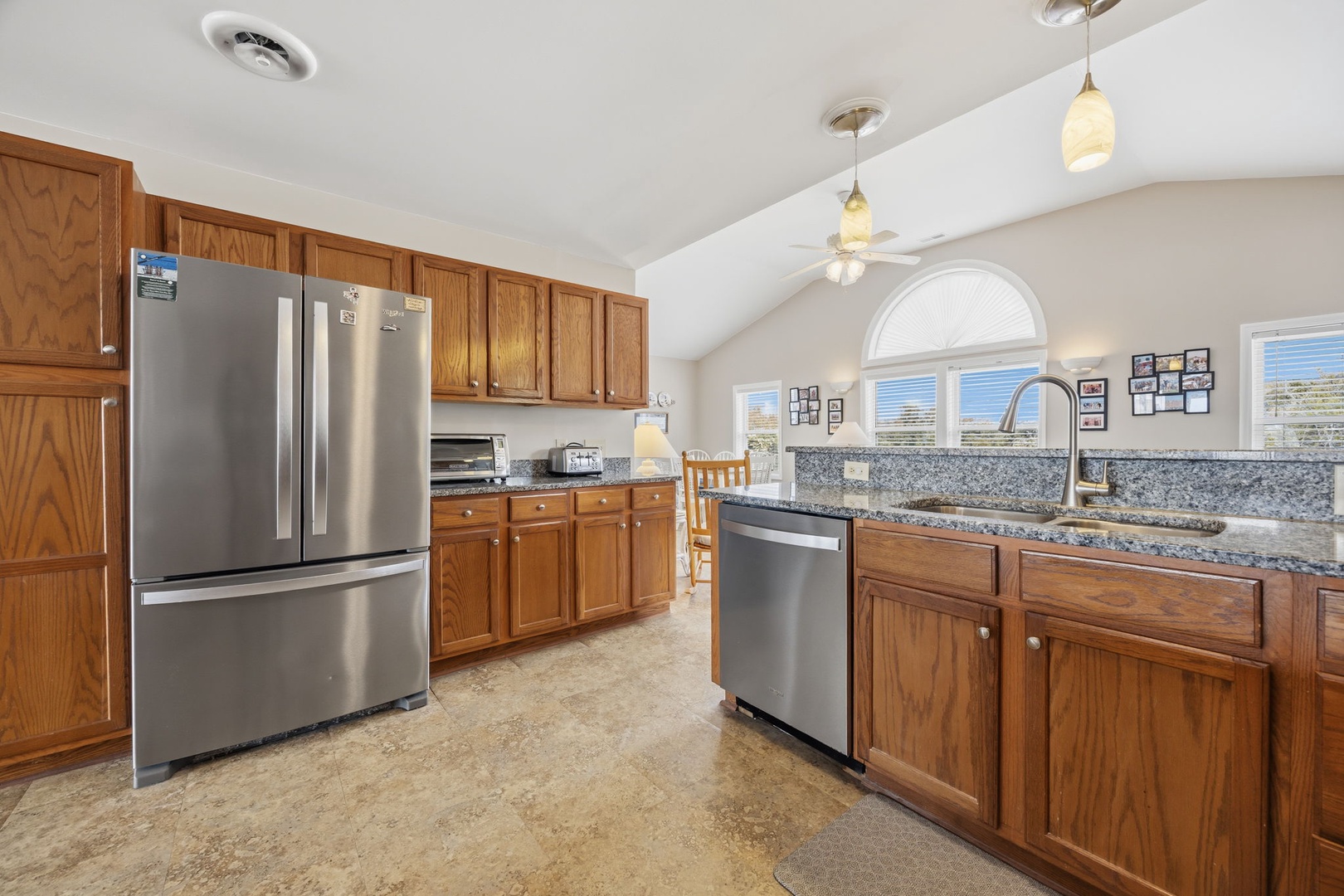 Cook up your vacation memories in this spacious kitchen featuring granite counters, stainless steel appliances, and warm wood cabinetry with ample storage.