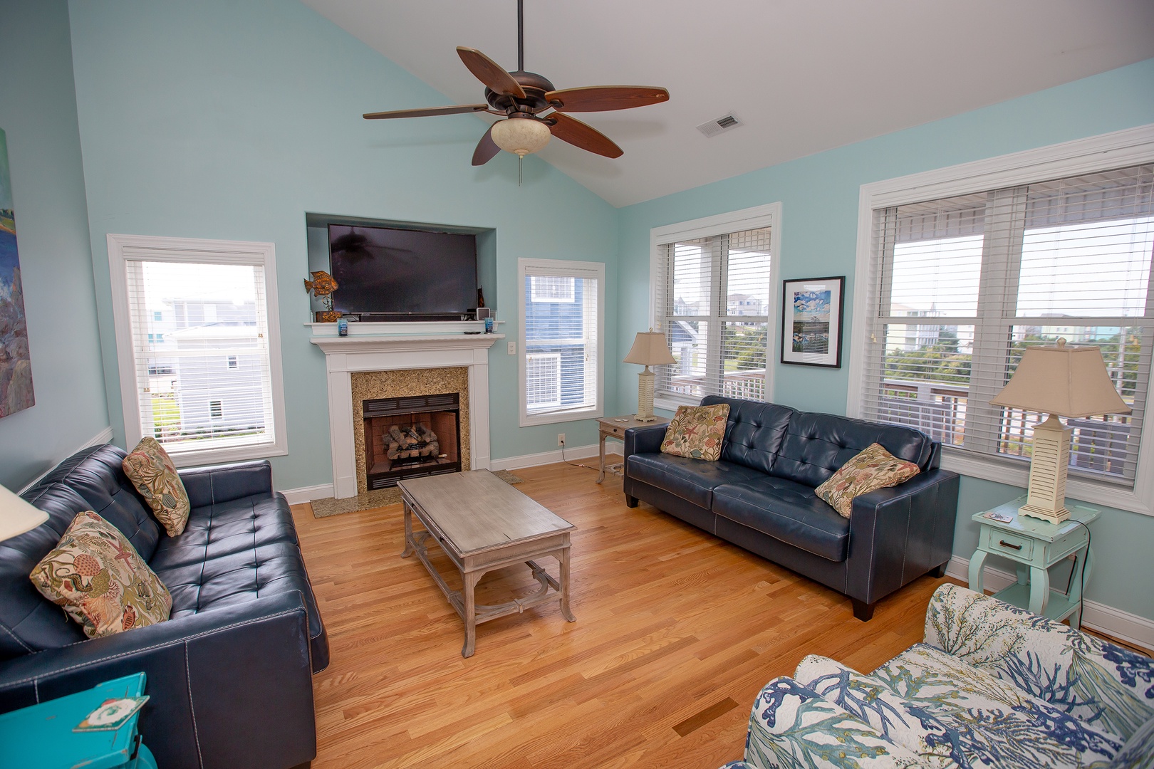 Relax in your bright living room with comfy leather sofas, warm fireplace, and large windows letting in natural light.