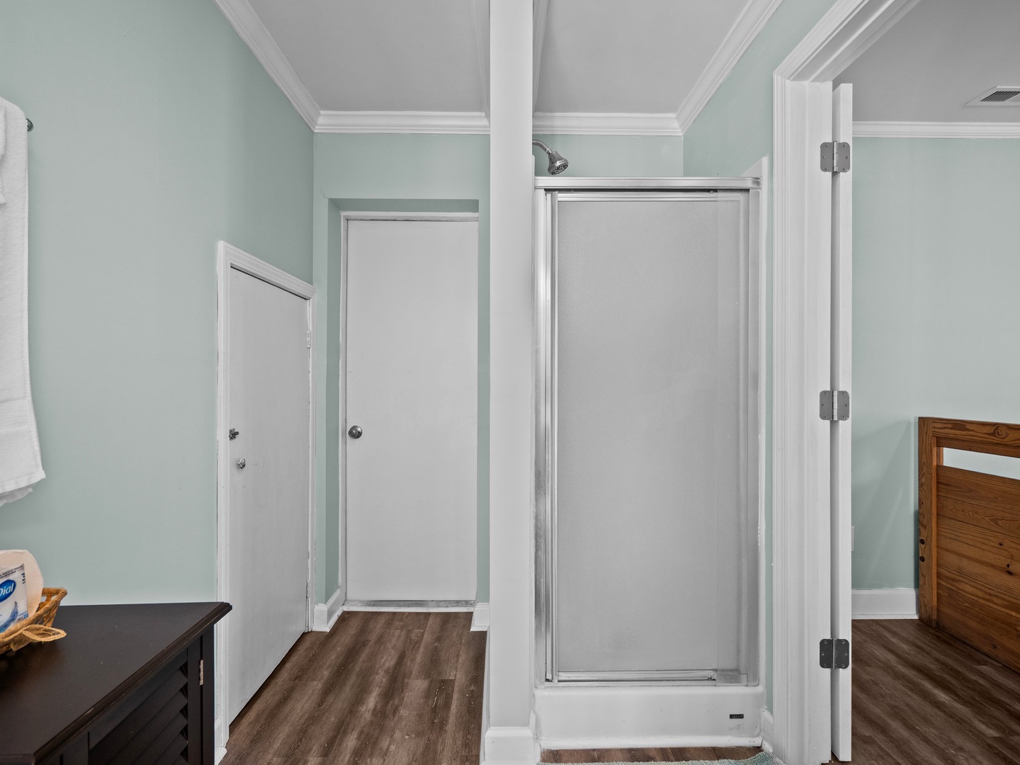 Step into your spa-like bathroom retreat with a pristine glass shower, crisp white finishes, and serene mint walls that create pure tranquility.