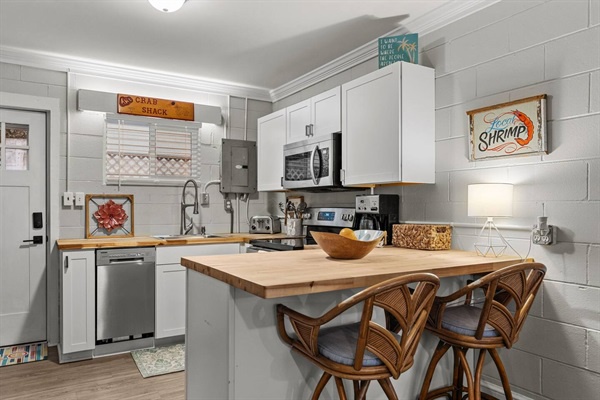 Your fully-equipped kitchen invites you to cook with stainless appliances, butcher block island, and coastal charm throughout.