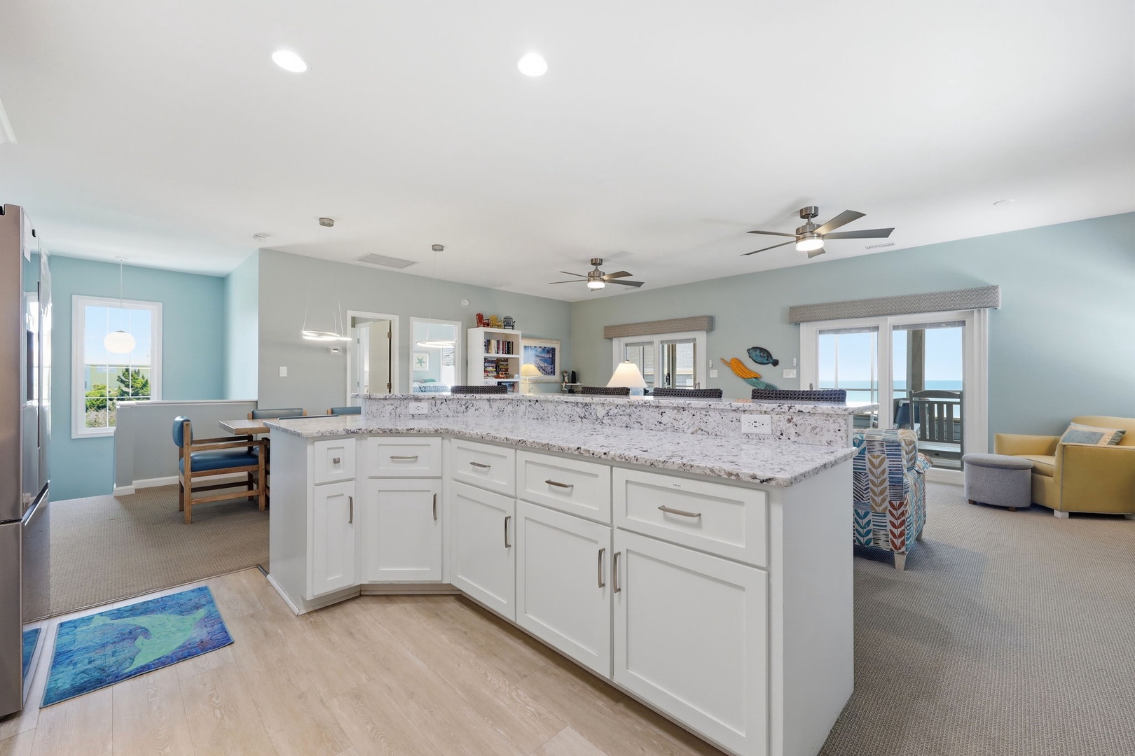 Gather in your bright, open kitchen with sparkling granite counters and coastal views beyond. Cook, relax, and unwind in this airy space designed for comfort and connection.