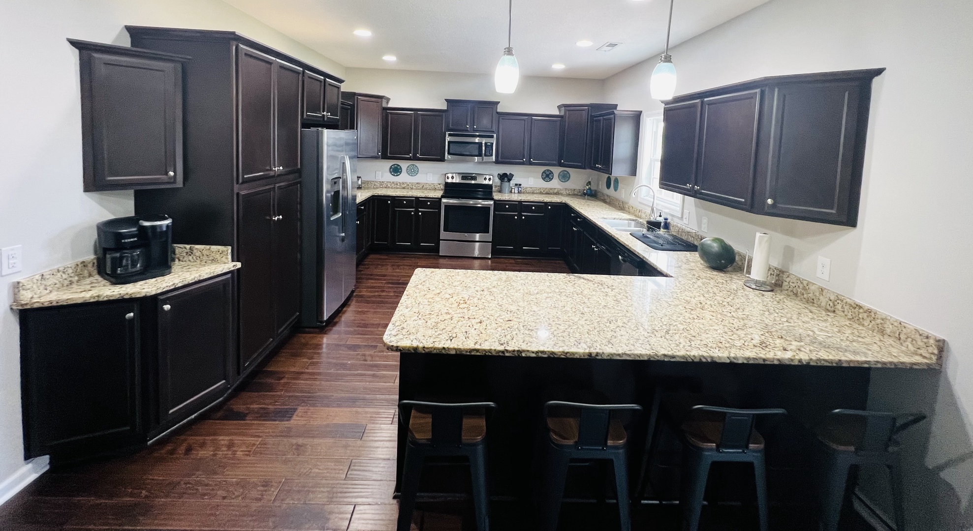 Your spacious gourmet kitchen awaits with granite countertops, stainless appliances, and a breakfast bar perfect for morning coffee or evening conversations.