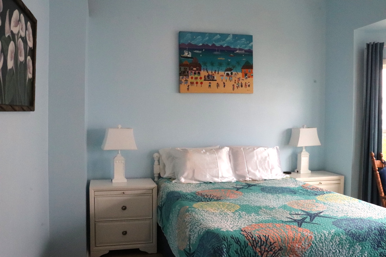 Sink into coastal comfort with soft beach-themed linens and serene blue walls that invite restful sleep. Bedside lamps and beachy art complete your seaside sanctuary.