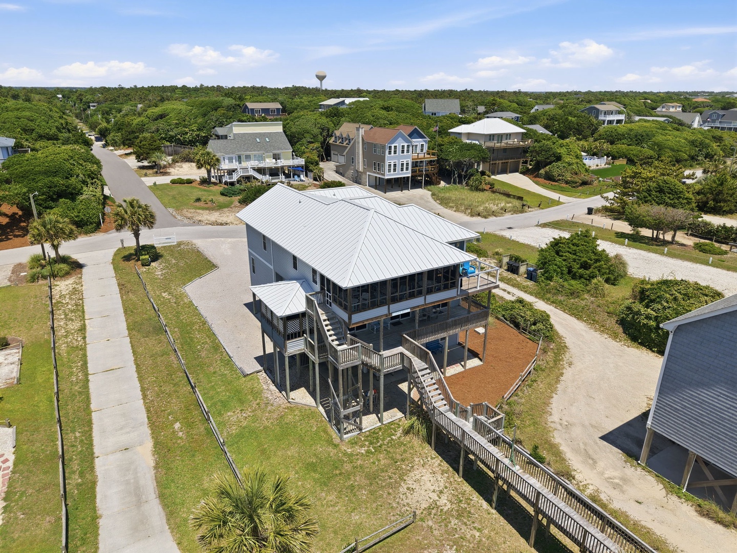 This elevated coastal home sits in a quiet, tree-lined neighborhood just moments from the beach, offering peaceful surroundings and easy access to island relaxation.