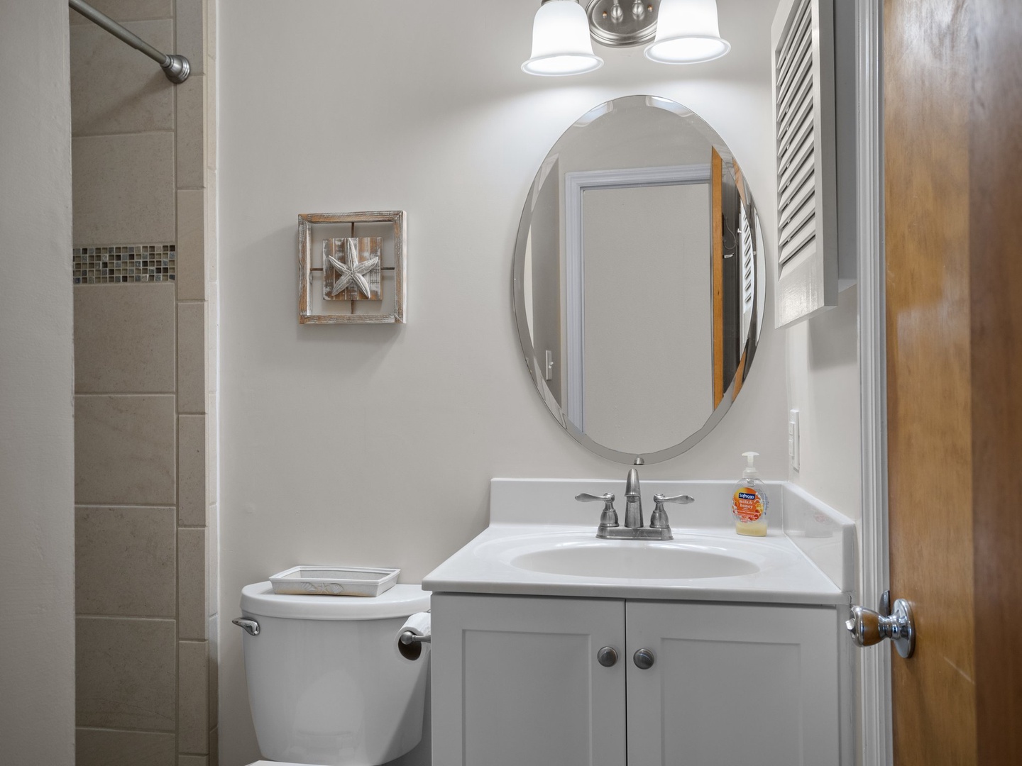Step into your beautifully appointed bathroom with modern fixtures, elegant oval mirror, and spacious walk-in shower for your daily refresh.