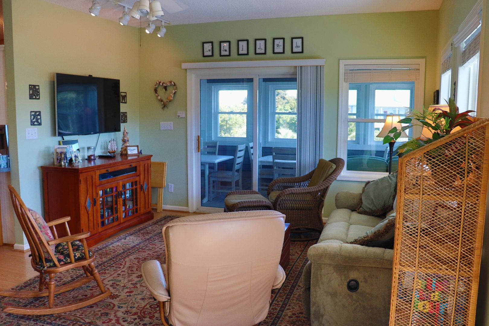 Unwind in your comfortable living room with plush seating, entertainment center, and peaceful views through French doors to your private outdoor space.