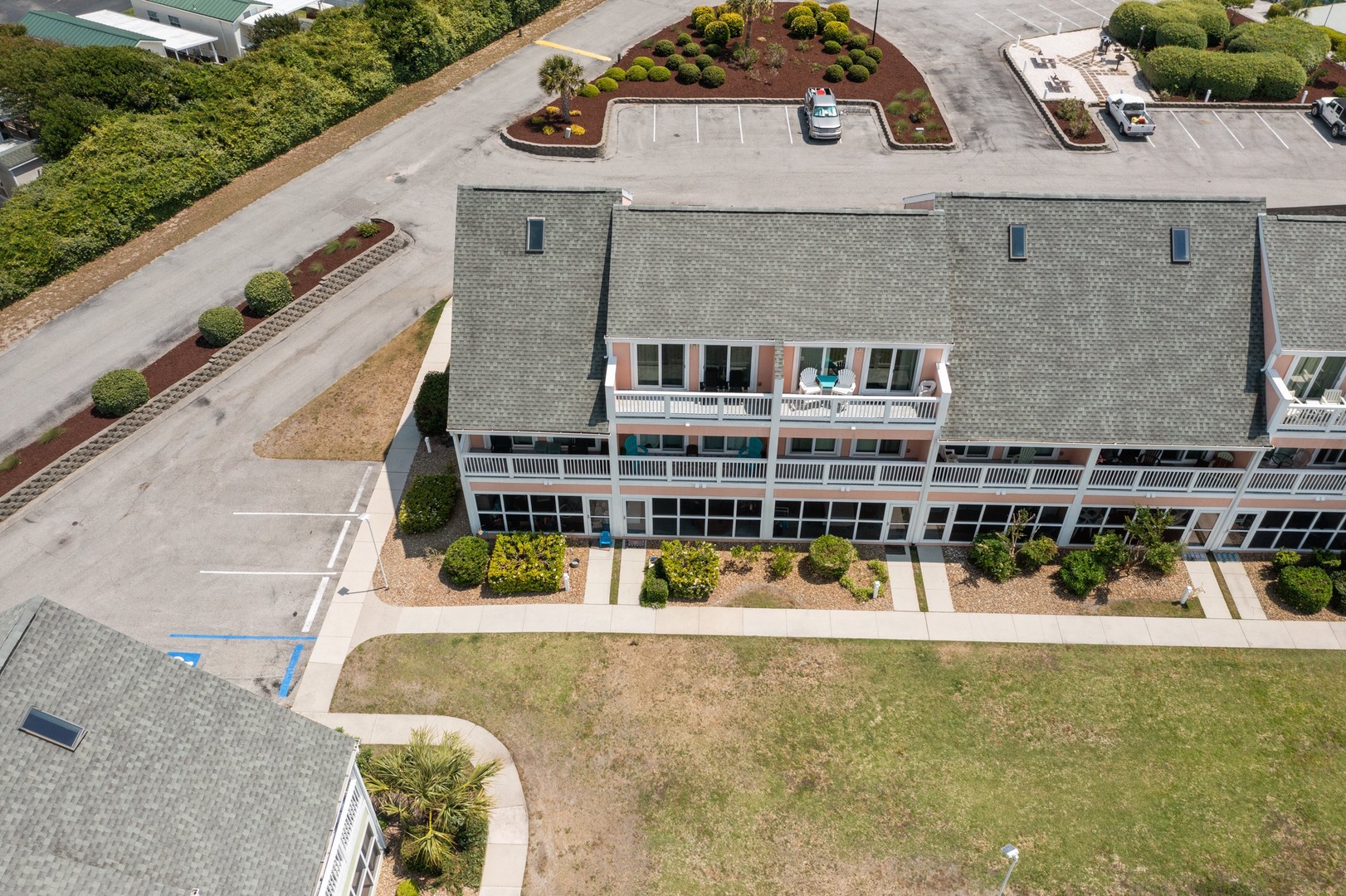 Multi-story residential complex with private balconies, landscaped grounds, and ample parking in a quiet neighborhood setting.