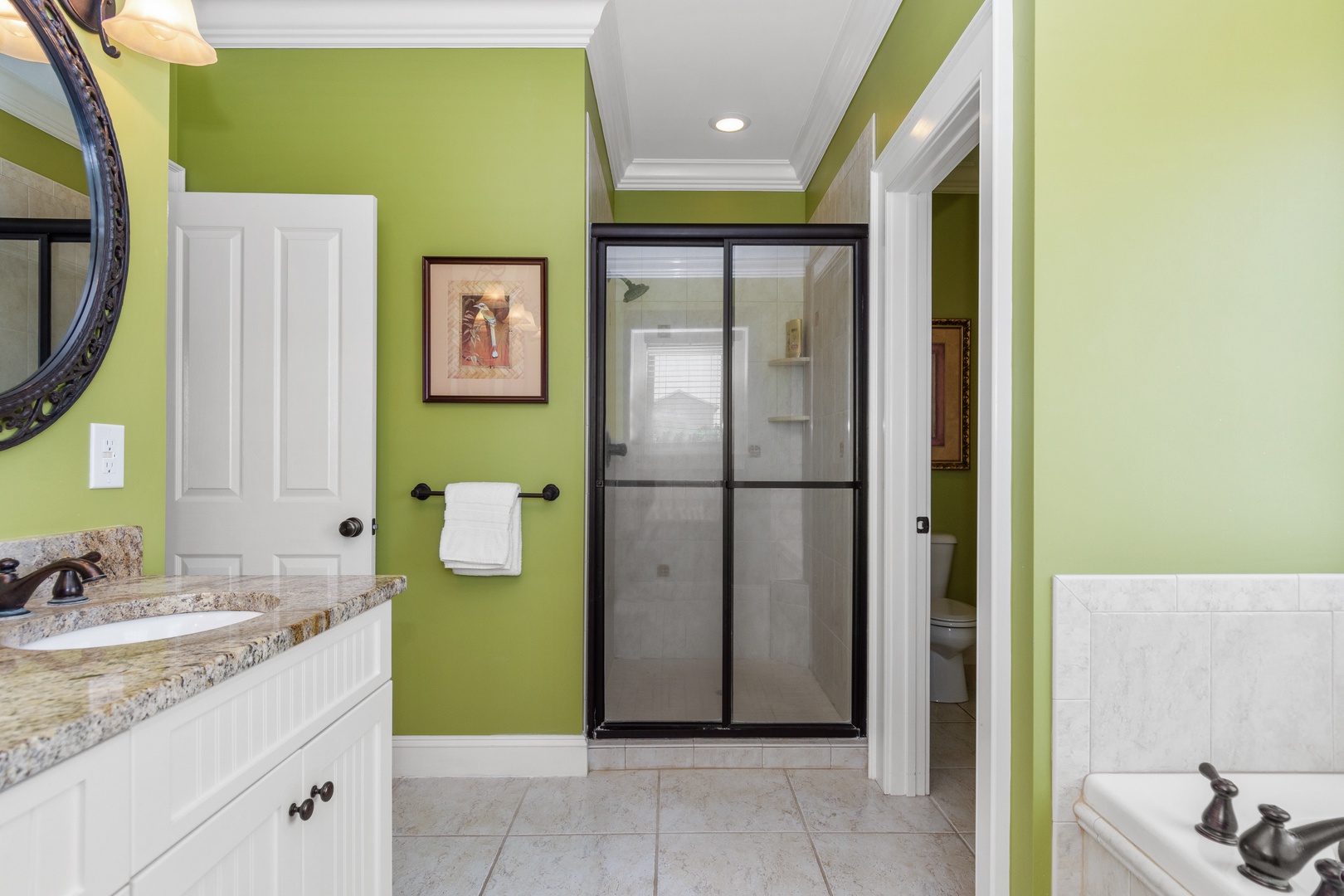 Refresh in your vibrant bathroom with granite counters, spacious walk-in shower, and cheerful green walls creating a spa-like retreat.