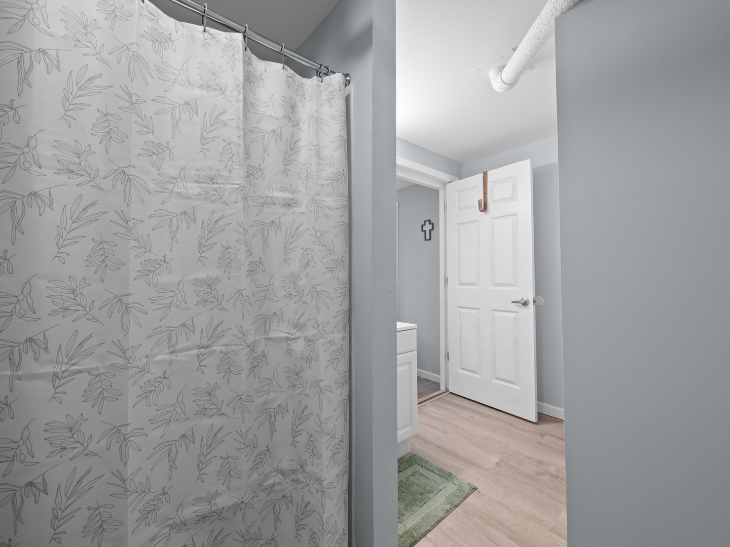 Step into your private bathroom featuring a stylish botanical shower curtain and fresh, clean design perfect for your morning routine.
