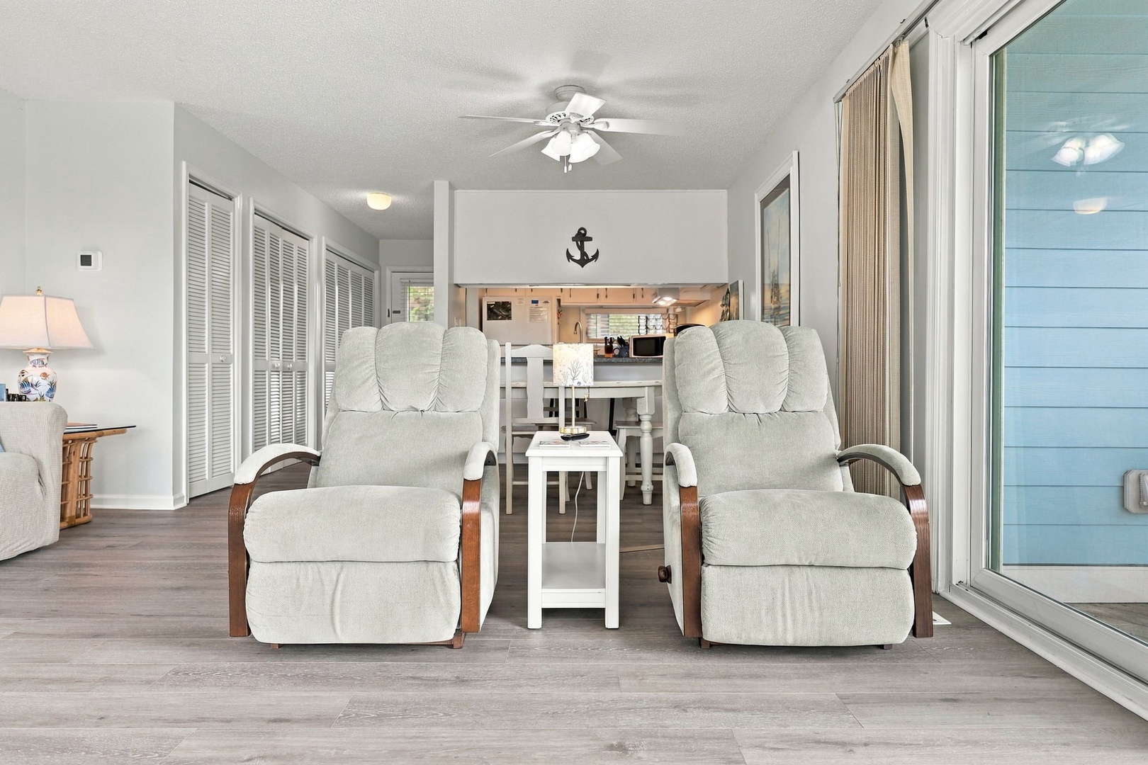 Relax in your bright, breezy living space with coastal charm. Sink into plush recliners, enjoy the ceiling fan's gentle breeze, and step through sliding doors to your private outdoor retreat.