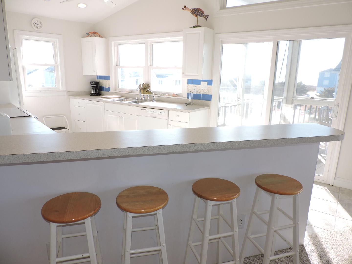 Your bright, airy kitchen features a breakfast bar where you can sip morning coffee while enjoying stunning water views through floor-to-ceiling windows.