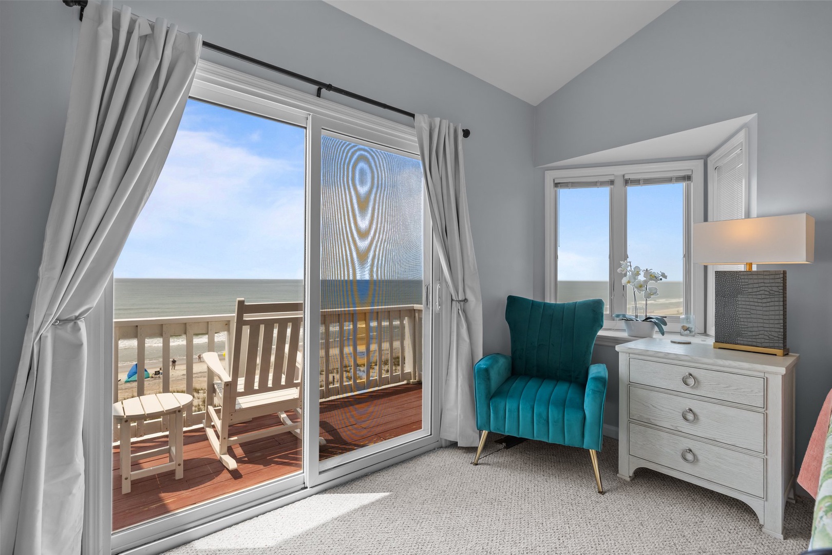 Your private retreat features a cozy reading nook with stunning ocean views, where you can unwind in the plush turquoise armchair while watching the waves.