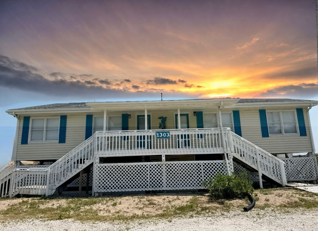 Beachfront property with elevated design and dramatic sunset skies creating a stunning coastal backdrop.