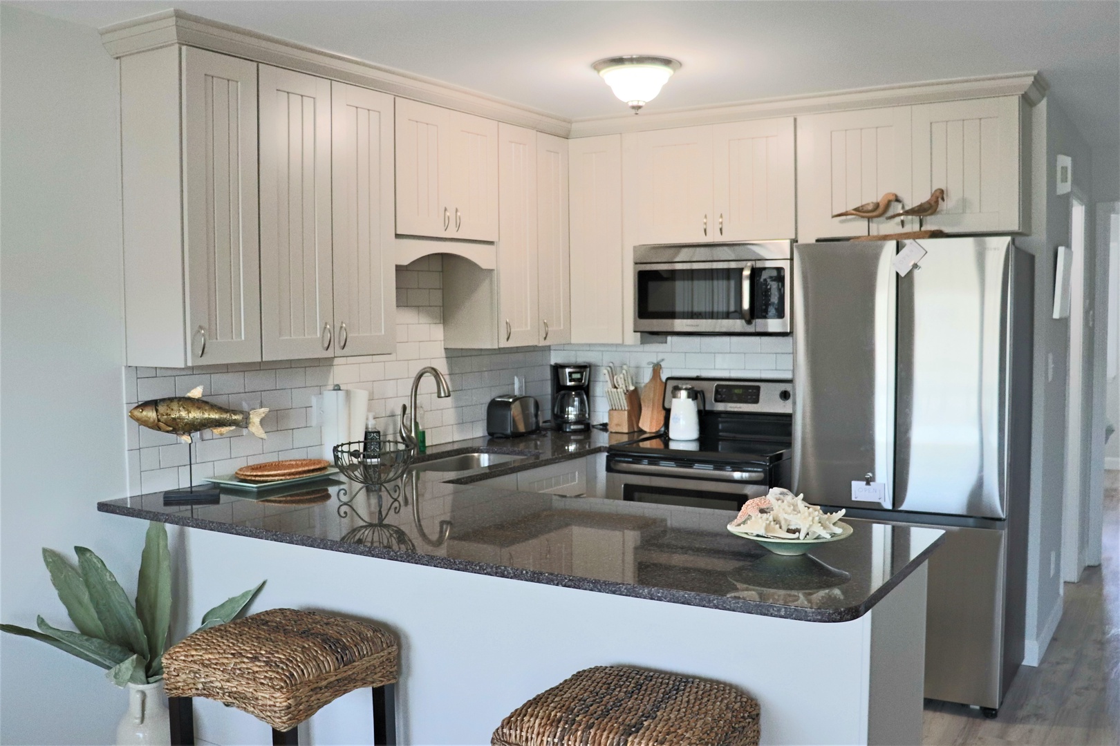 Your fully equipped kitchen features granite countertops, stainless steel appliances, and coastal charm—perfect for preparing memorable meals during your stay.