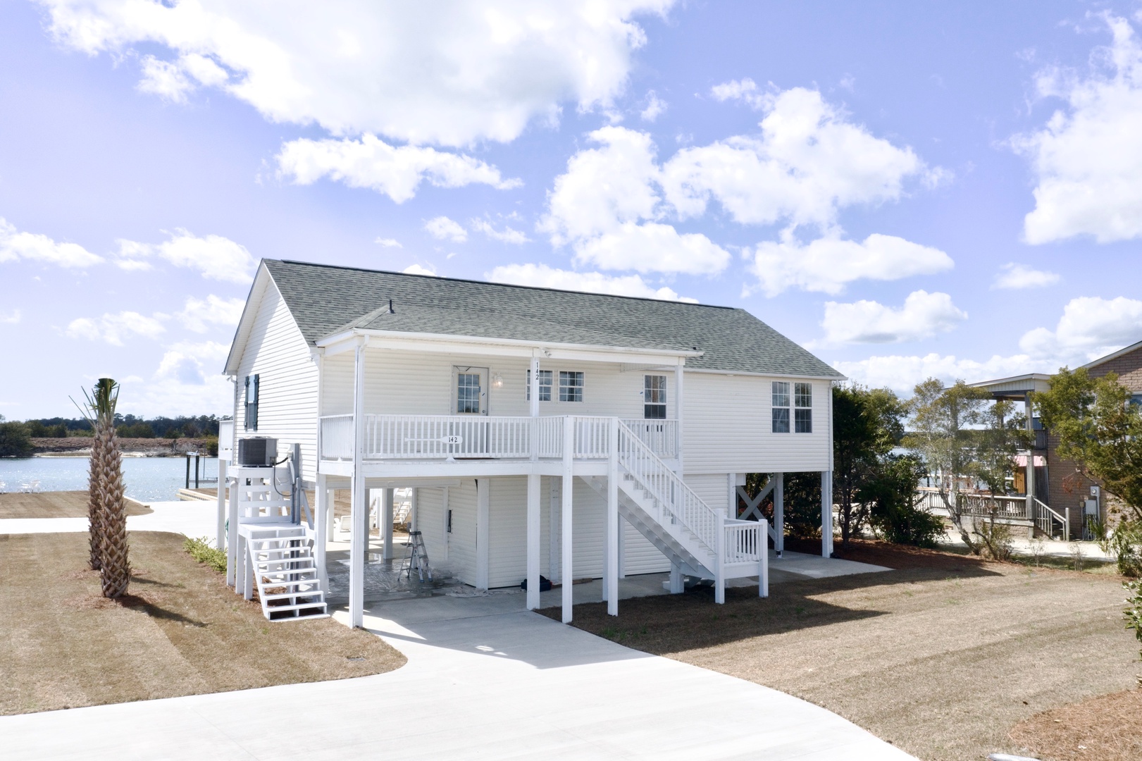 Charming elevated coastal cottage with waterfront views and private balcony in peaceful waterside community.