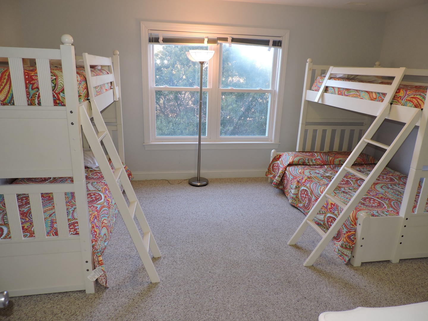 Your family will love this cheerful bunk room with colorful bedding and natural light streaming through tree-lined views.