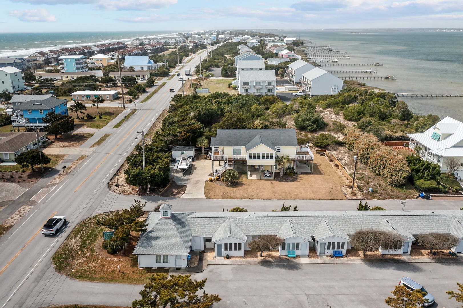 Coastal community featuring vacation rental properties with direct beach access and scenic waterfront piers stretching into calm waters.