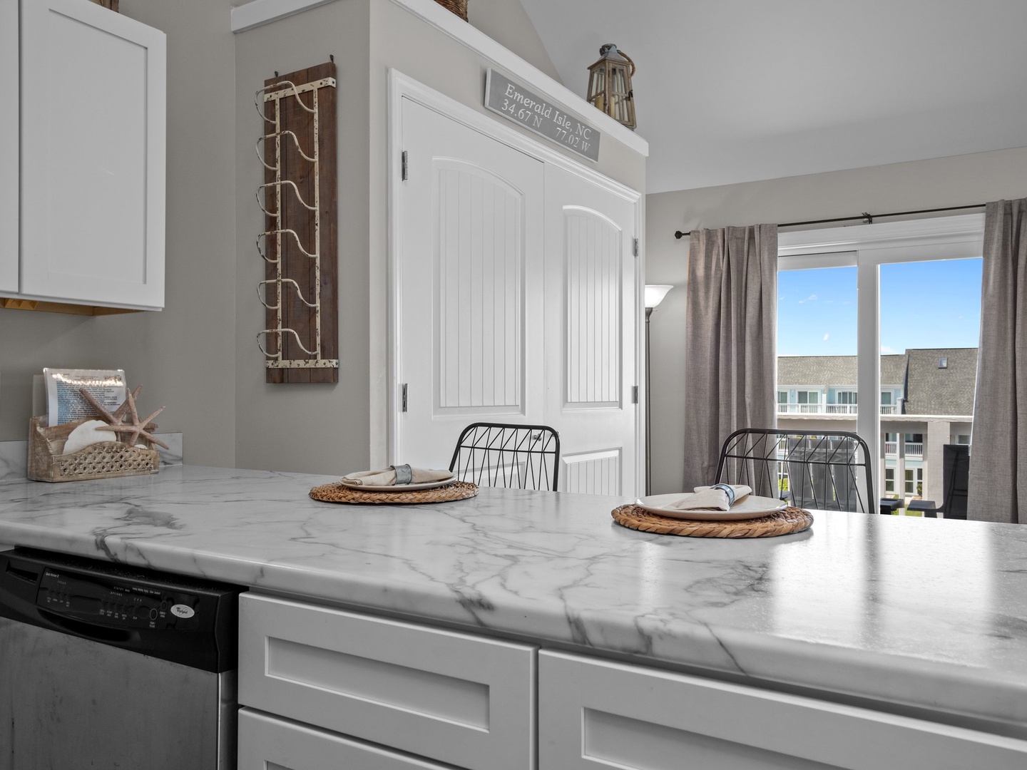 Your bright kitchen features marble countertops and coastal charm, perfect for preparing meals while enjoying natural light.