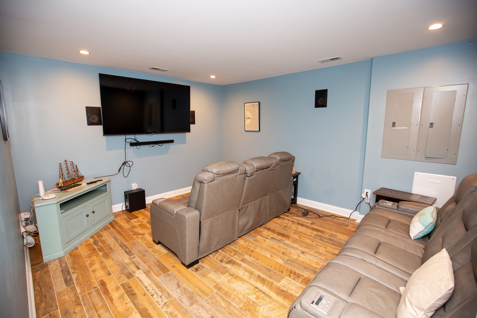 Sink into plush recliners and enjoy movie nights in your private entertainment room with wall-mounted TV and soothing coastal colors.