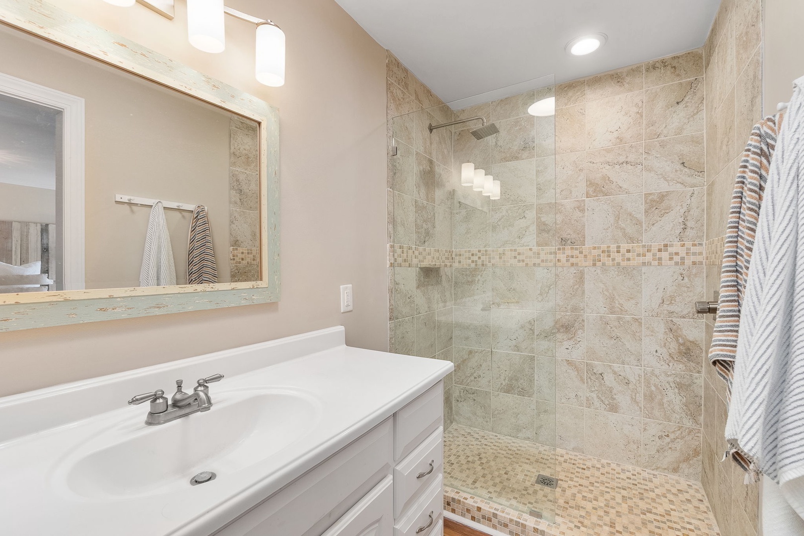 Step into your private spa-like retreat with elegant marble tiling, spacious glass shower, and fresh towels awaiting your arrival.