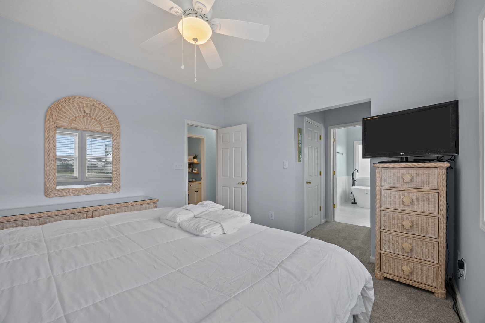 Drift off peacefully in your comfortable bedroom with coastal wicker furnishings and cooling ceiling fan overhead.