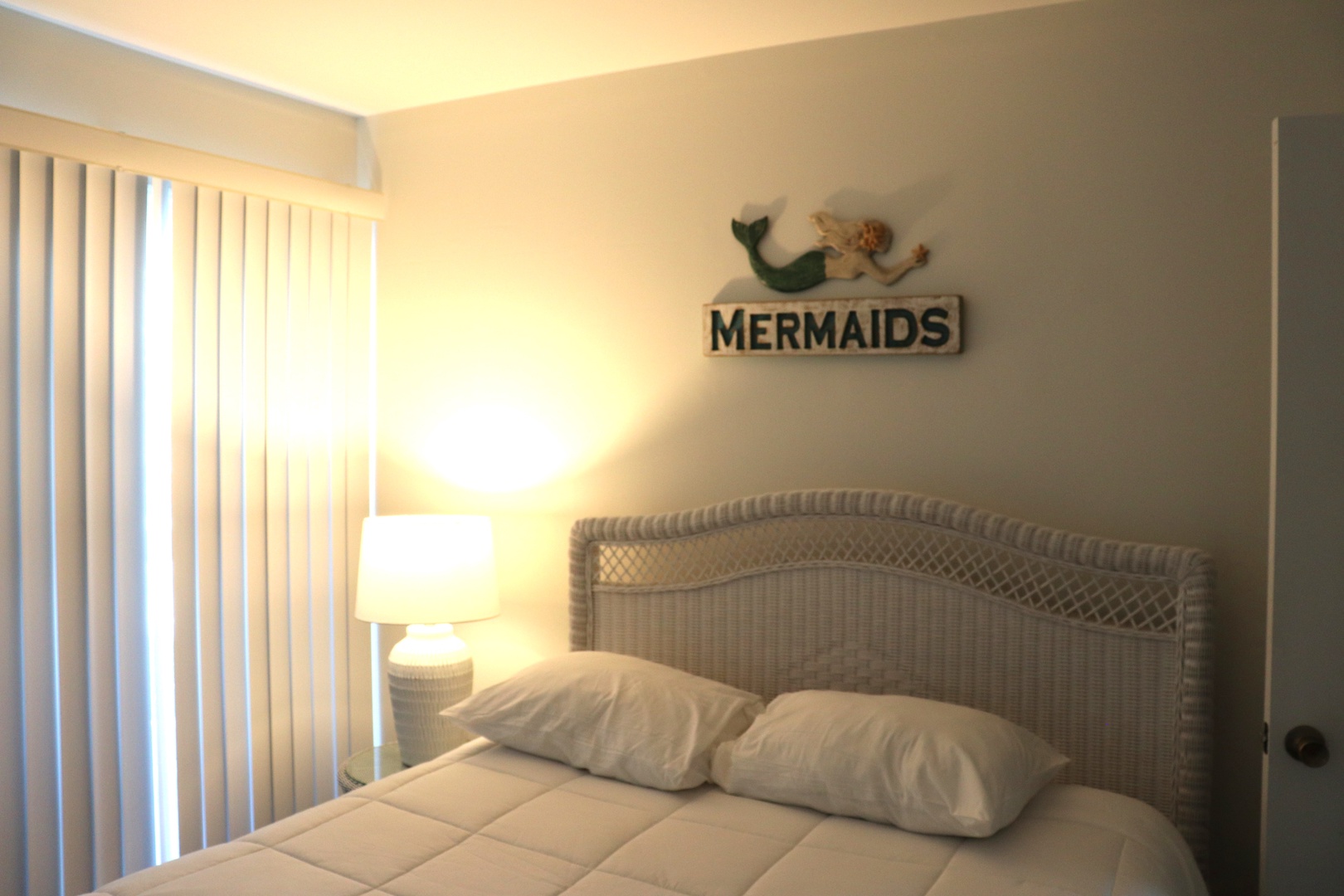 Drift off to sleep in your cozy coastal-themed bedroom, where soft lighting and mermaid decor create a whimsical seaside retreat.