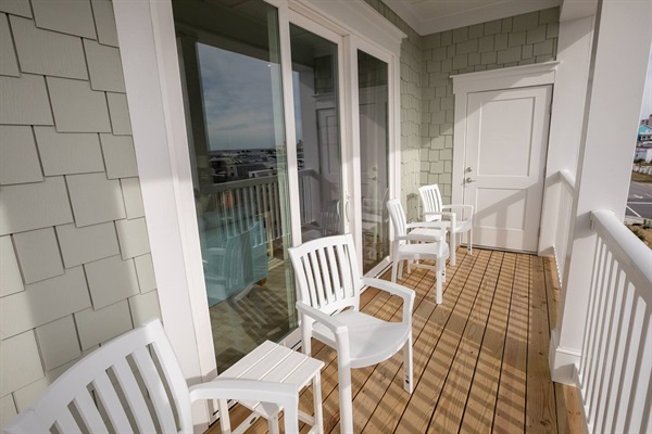 Your private balcony awaits with cozy seating and stunning water views through French doors.