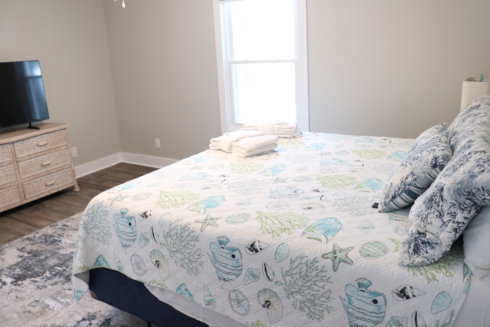 Drift off to sleep in your serene bedroom with ocean-themed linens, natural light streaming through windows, and coastal charm throughout.