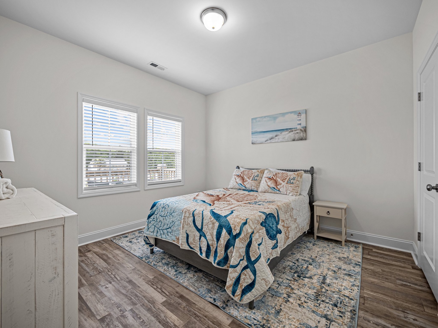 Your serene bedroom features ocean-themed decor and soft natural light, creating the perfect coastal retreat for restful nights.