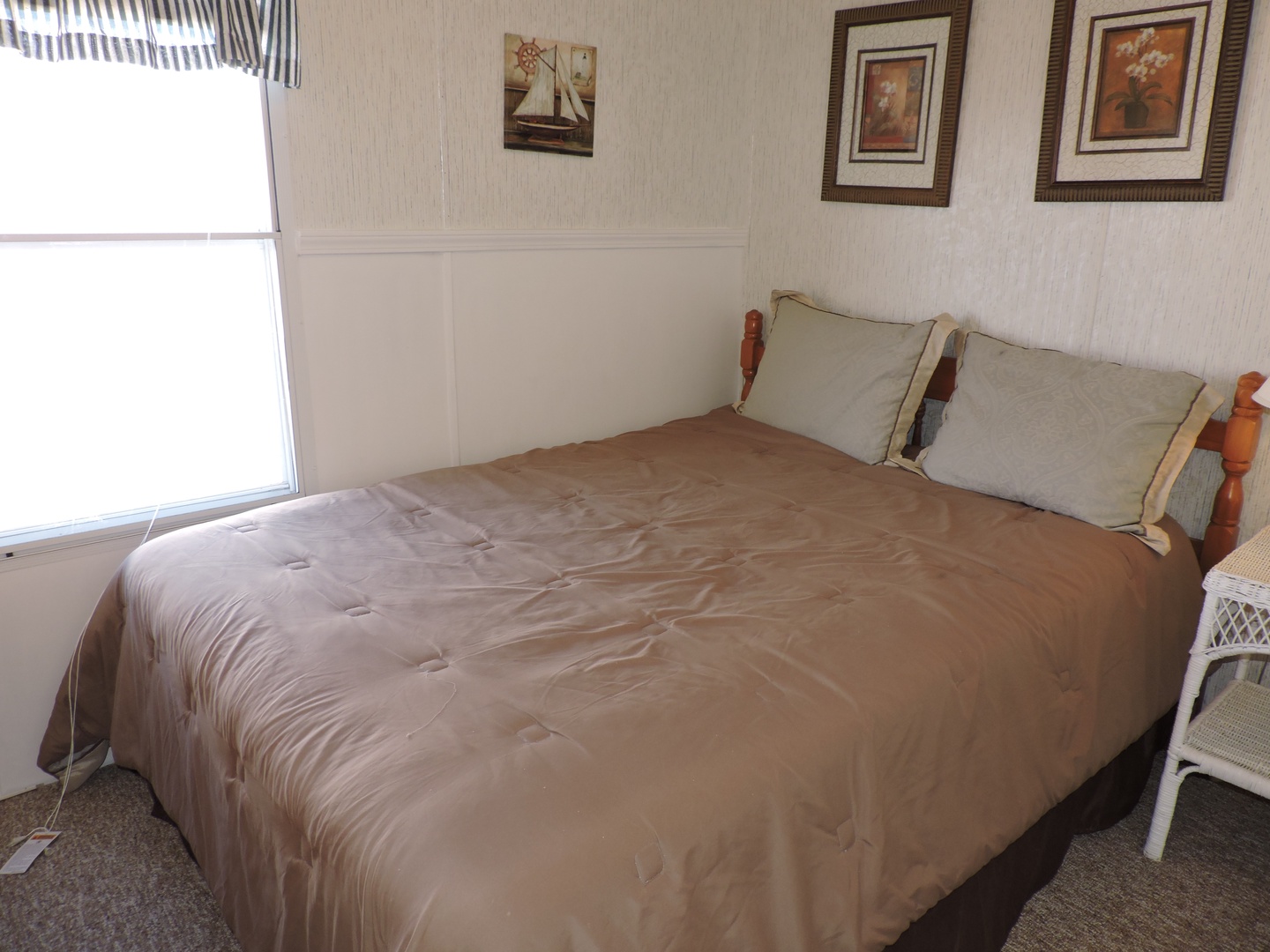 Drift off to sleep in your cozy bedroom, where natural light and nautical artwork create a peaceful coastal retreat.