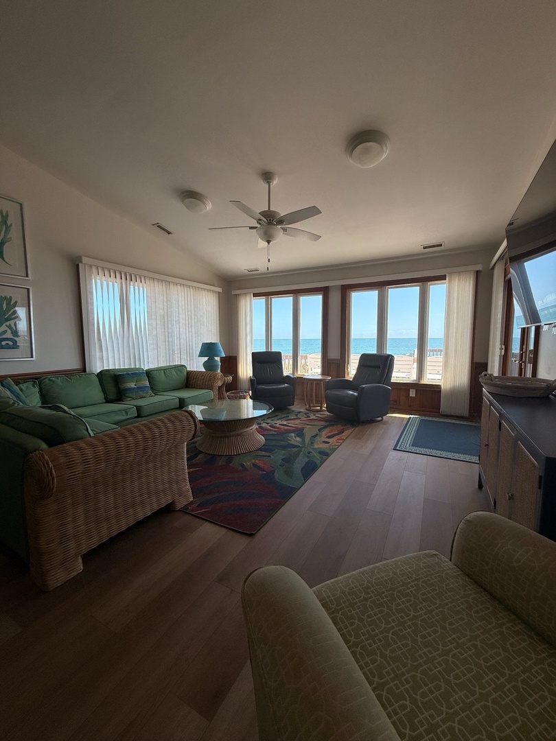 Sink into plush seating and gaze out at the stunning ocean through floor-to-ceiling windows. Your beachfront retreat invites you to unwind in coastal comfort with endless views.