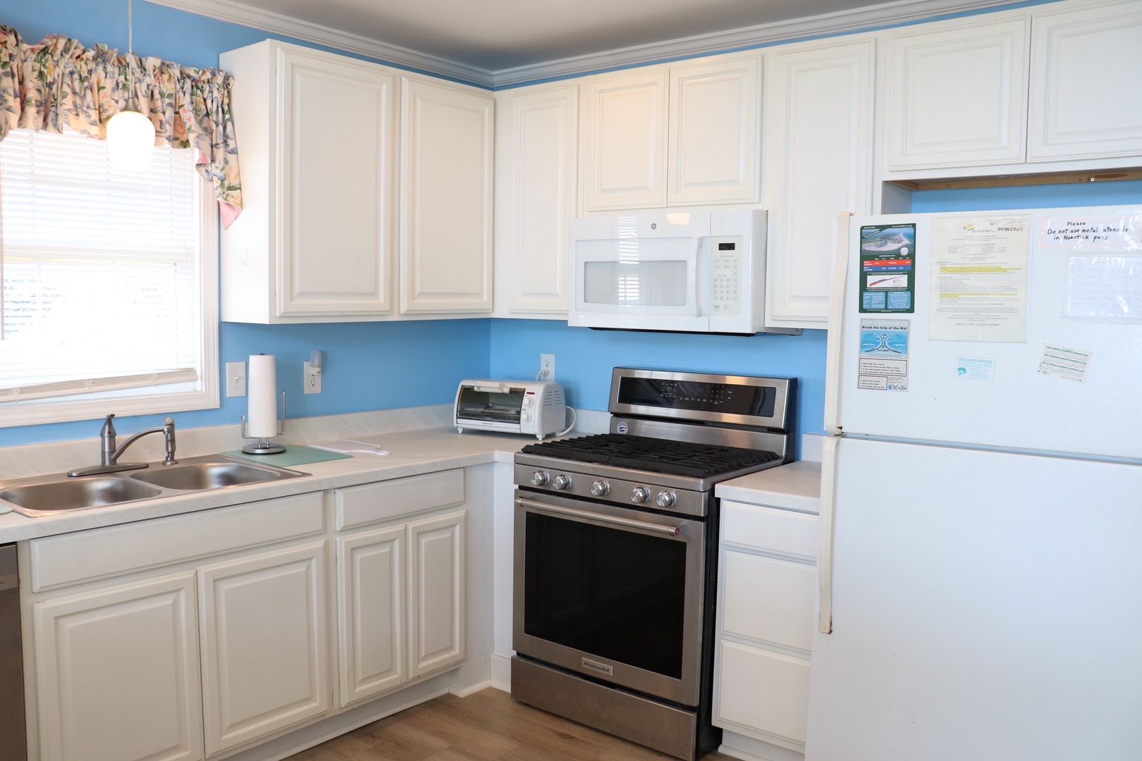 Your bright, fully-equipped kitchen features everything for cooking meals, with cheerful blue accents and modern appliances for your convenience.