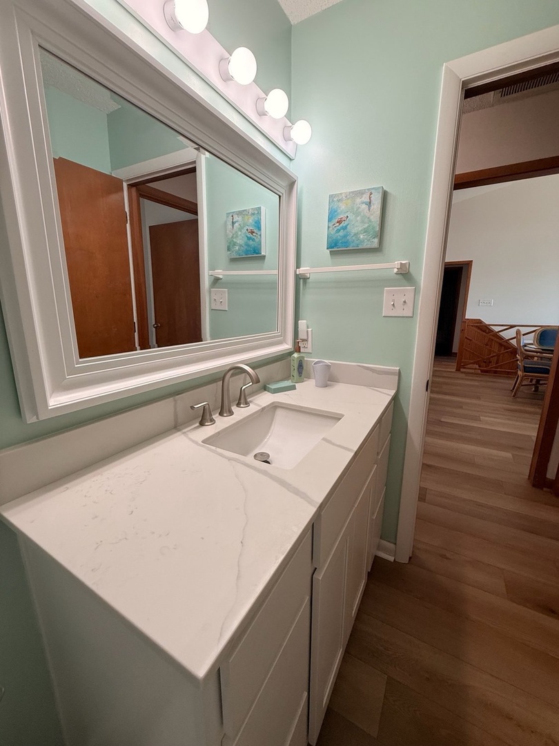 Freshen up in your serene, coastal-inspired bathroom with soothing mint walls, modern fixtures, and soft lighting that sets the perfect tone for relaxation.