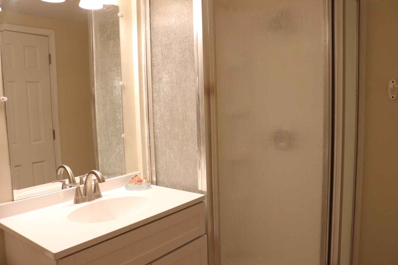 Your private bathroom features a spacious vanity with modern fixtures and a frosted glass shower door for comfortable daily routines.
