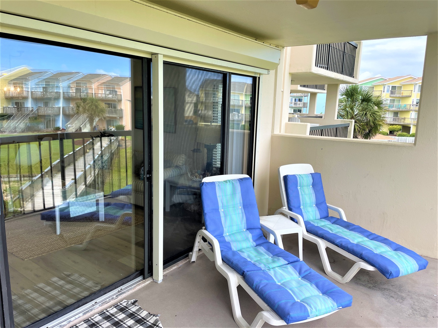 Your private balcony invites lazy afternoons lounging on comfortable chairs with coastal views beyond.