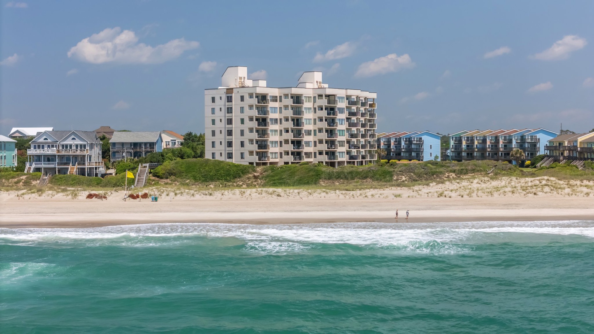 Beachfront property complex with direct beach access and stunning ocean views in a coastal community setting.