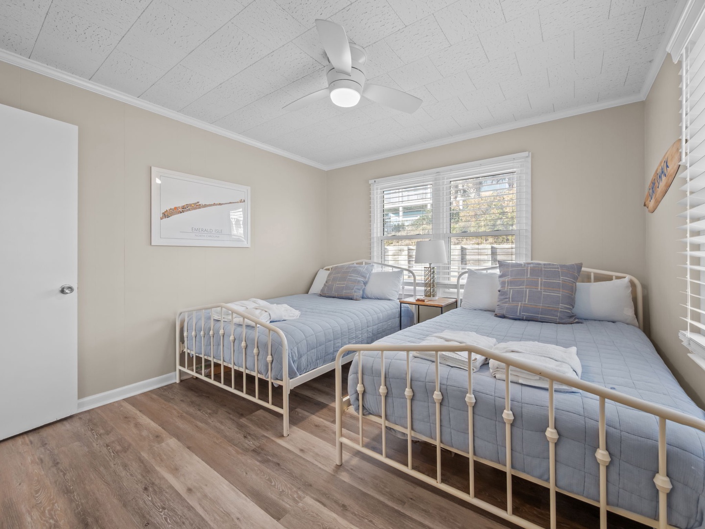 Rest peacefully in your cozy twin bedroom with soft blue bedding and gentle natural light streaming through the windows.