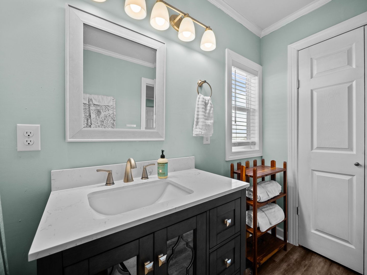 Step into your serene bathroom sanctuary with calming mint walls and warm brass fixtures creating the perfect retreat.